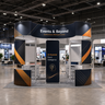 Stand îlot de 6x6 m avec panneaux muraux incurvés et étagères d'exposition